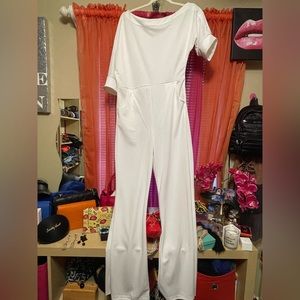 All while large, belted pants jumper, straight legs, one side off shoulders.